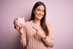 woman pointing to piggy bank pink
